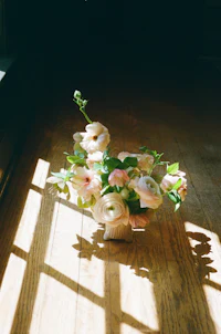 a vase of flowers sitting on a wooden floor